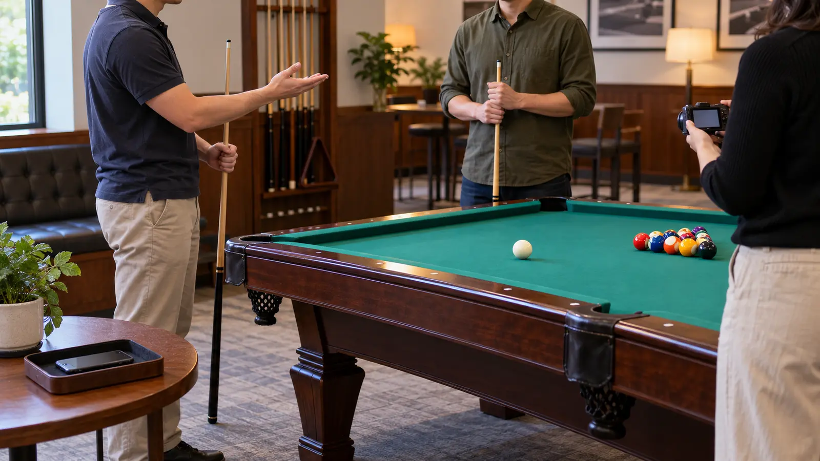 Phone face down in a tray away from a pool table while players agree before a camera is used