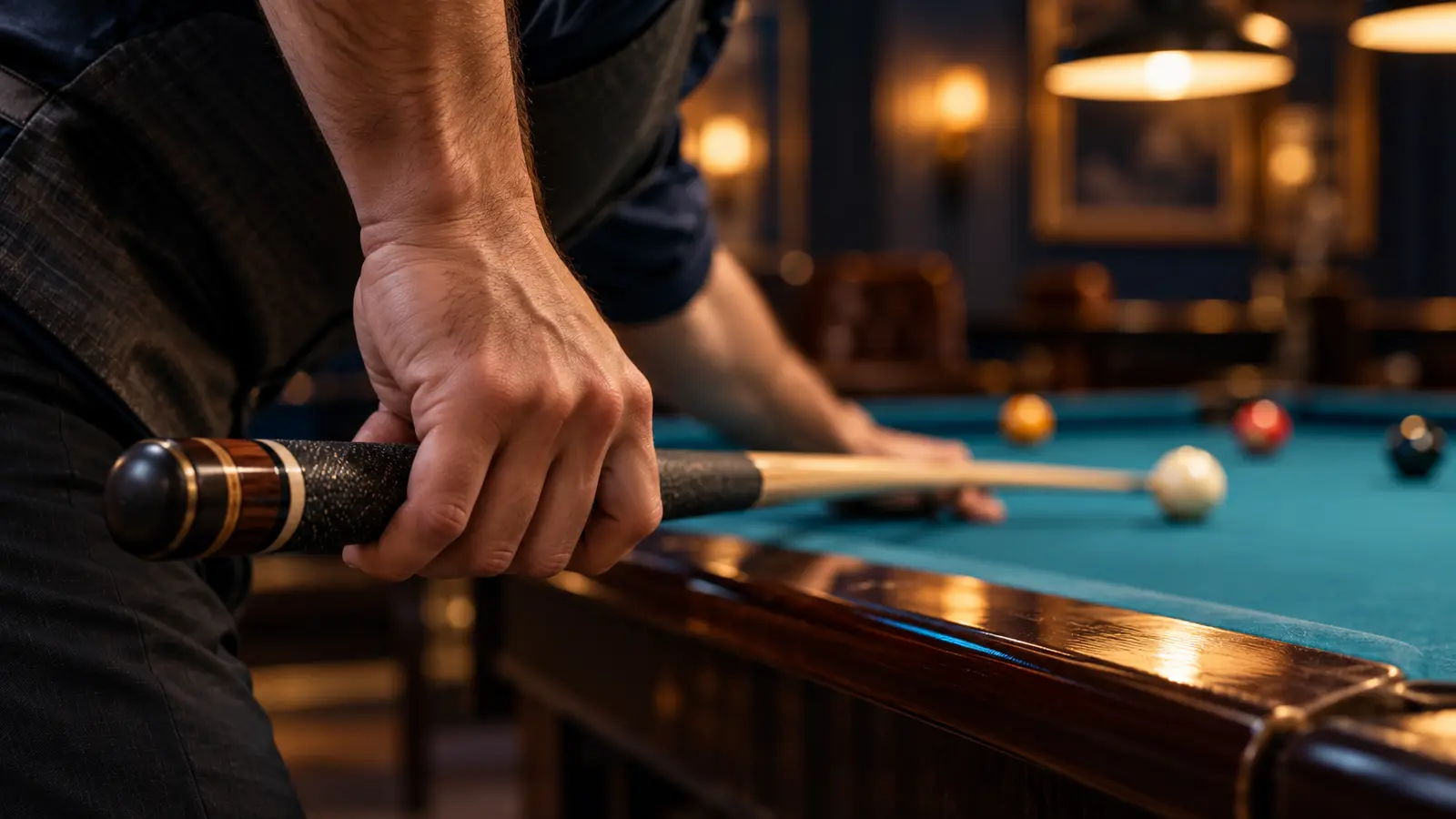 Editorial close-up of a pool player cradling a cue with a relaxed rear hand while the wrist hangs naturally