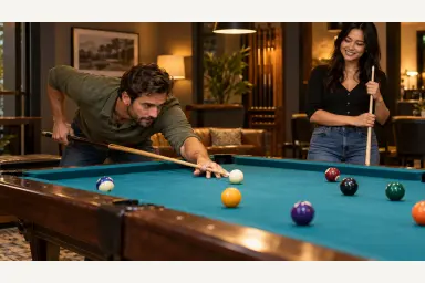 Two friends enjoying a relaxed pool game while one player keeps a stable bridge and deliberate stance